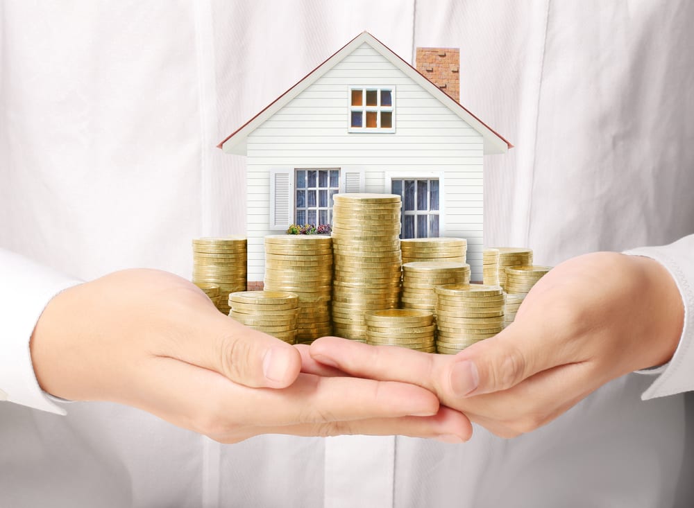 Concept of cost of living, house with coins in hands.